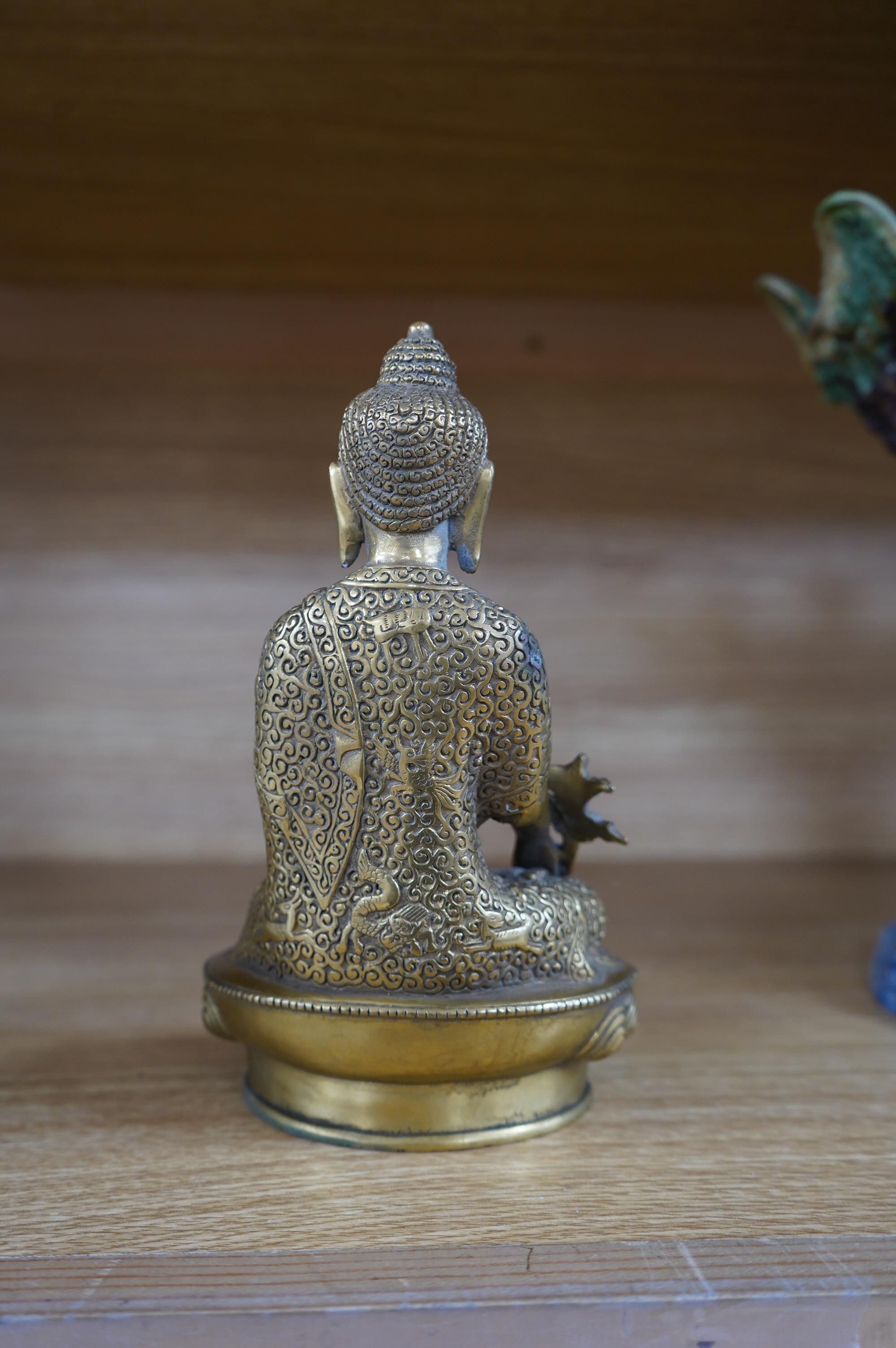 A Tibetan bronze model of a seated Buddha, 19cm. Condition - fair to good